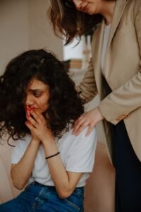 A young woman receiving comforting support in a counseling session.