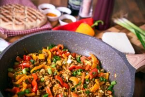 Delicious stir-fry with vibrant bell peppers and fresh ingredients in a cooking pan.