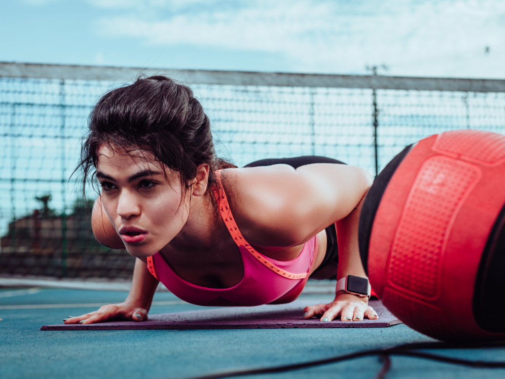 Woman doing push-ups on a sports court in Ji-Paraná, Brasil, focusing on fitness outdoors.