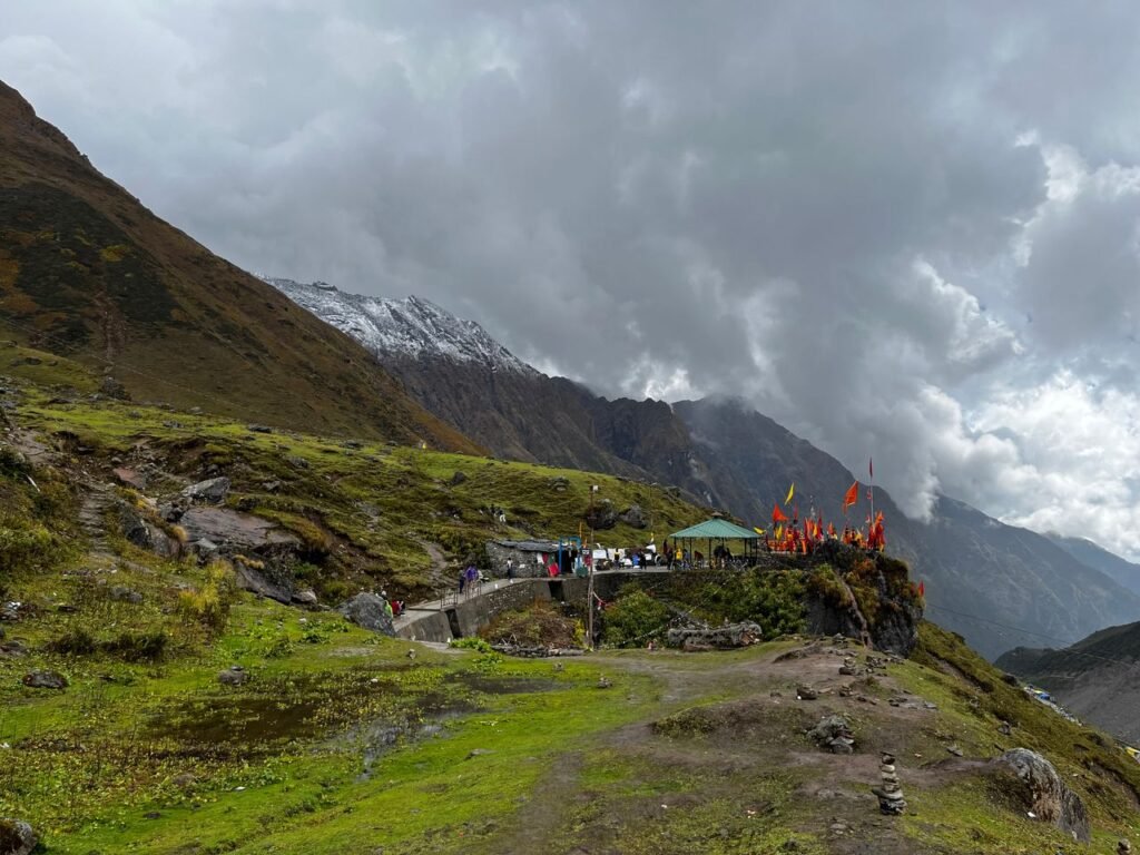 Scenic view of hikers and flags on a mountain under a dramatic cloudy sky.