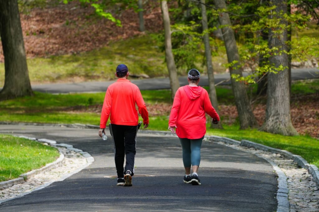A couple enjoys a walk through a lush green park on a bright spring day.