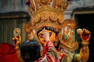 A devotee performs a ritual on a Durga idol during a Hindu festival celebration.
