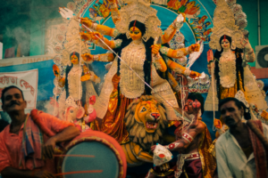 Colorful Durga Puja festival scene with devotional figures and vibrant decorations.