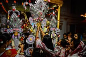 A dynamic scene capturing devotees worshiping Durga idols during Durga Puja in Kolkata, India.